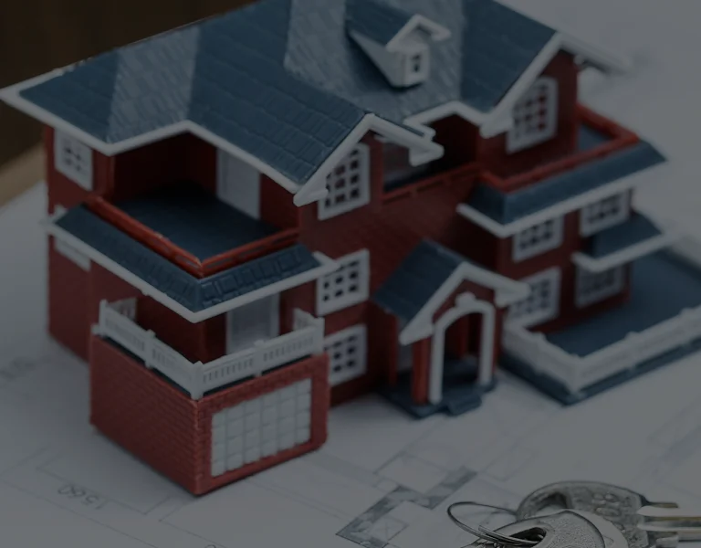 Detailed miniature model of a red brick house with blue roof on architectural plans.